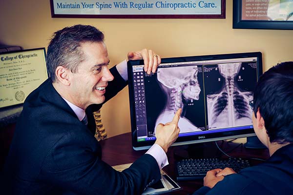 Chiropractor Oak Creek WI Daniel Hyatt Reviewing X-Rays to Patient