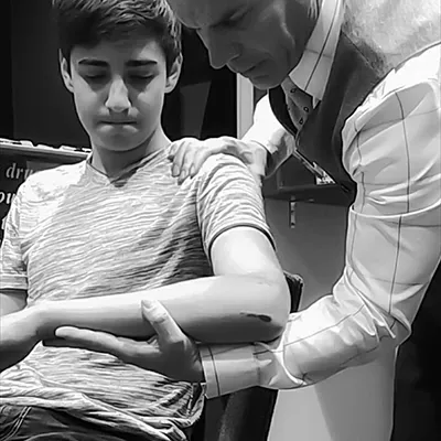 Chiropractor Oak Creek WI Daniel Hyatt Examining Boys Arm