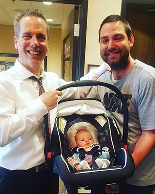 Chiropractor Oak Creek WI Daniel Hyatt Holding Infant In Carseat
